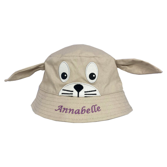 Beige bucket hat with dog face design and 'Annabelle' text on a white background