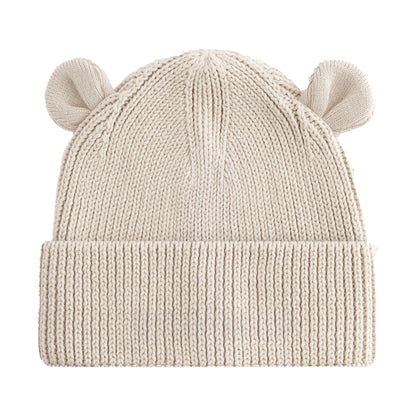 A cream-colored ribbed knit beanie hat with small bear ears on top, shown against a plain white background.