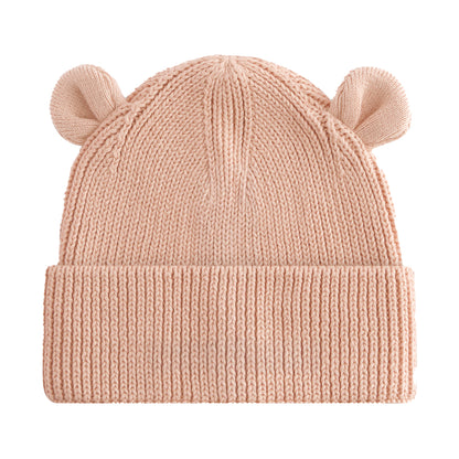 A light peach-pink ribbed knit baby beanie hat with small bear ears on top, shown against a plain white background.