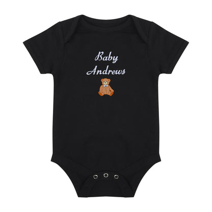 A black short-sleeve baby bodysuit with 'Baby Andrews' embroidered in white script above a small brown teddy bear graphic, shown on a plain white background.
