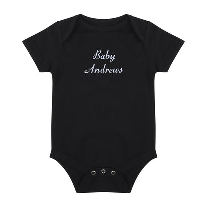 A black short-sleeve baby bodysuit with 'Baby Andrews' embroidered in white cursive text on the chest, displayed flat against a solid white background.