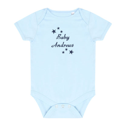 A light blue short-sleeve baby bodysuit with 'Baby Andrews' and star graphics embroidered in navy on the chest, displayed flat against a white background.