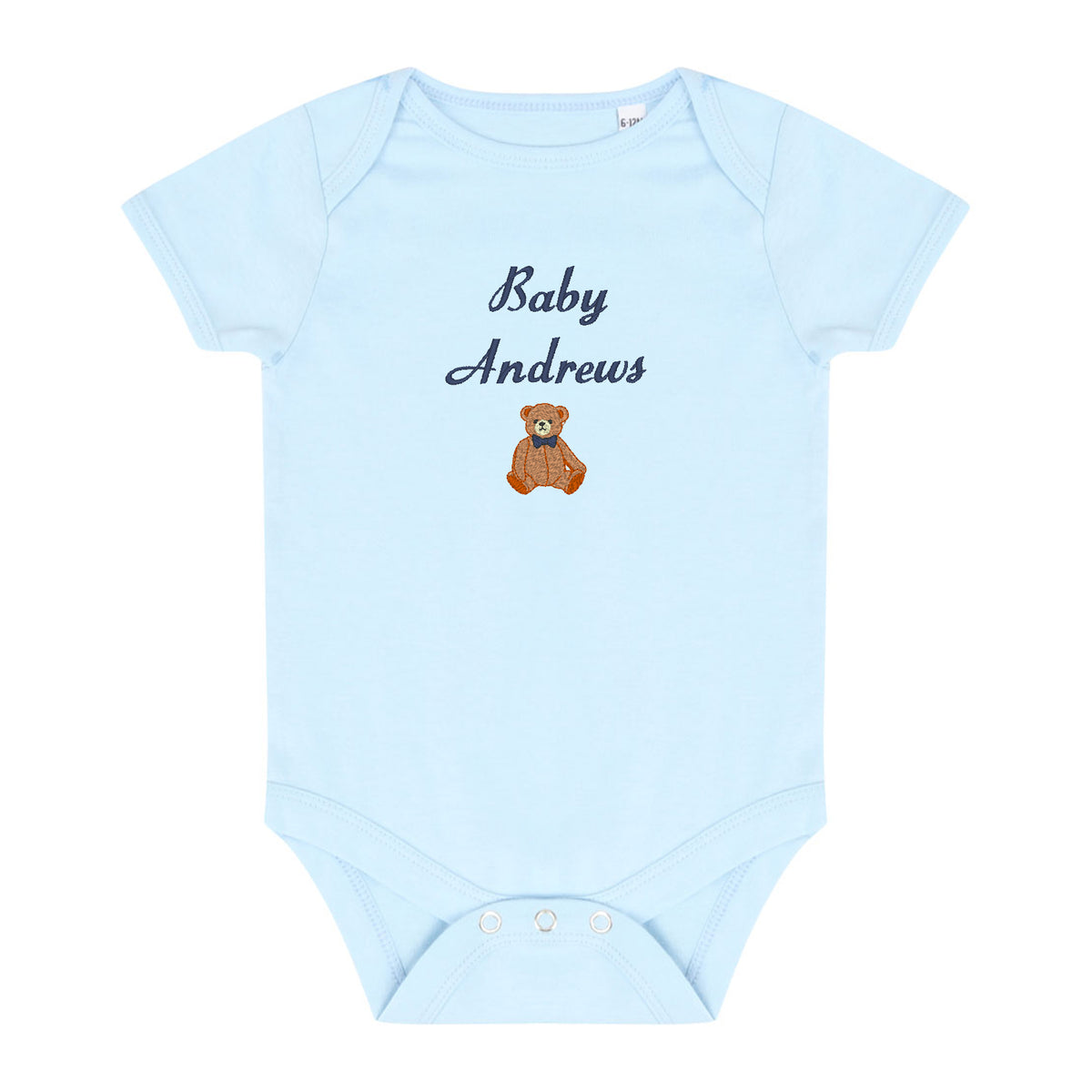 A light blue short-sleeve baby bodysuit with 'Baby Andrews' embroidered in navy script and a small brown teddy bear graphic on the chest, shown on a plain white background.