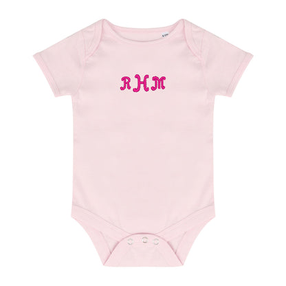 pale pink baby bodysuit with a pink embroidered monogram 