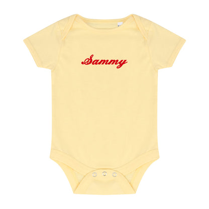 pale yellow bodysuit with red embroidered name 