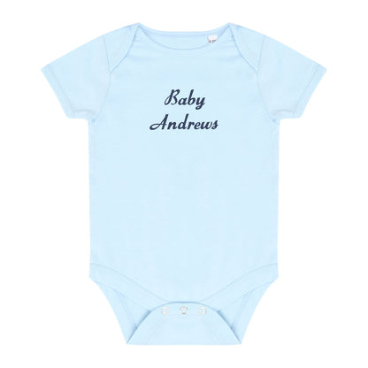 A light blue baby bodysuit with 'Baby Andrews' embroidered in dark navy script across the chest, displayed flat against a white background.
