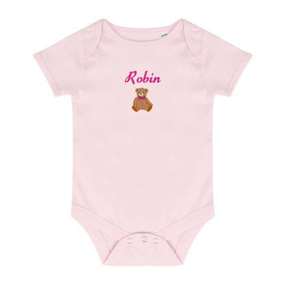 A light pink short-sleeve baby bodysuit with a custom name 'Robin' in pink script and a small brown teddy bear graphic on the chest, displayed on a solid white background.