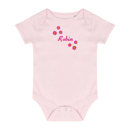 A light pink short-sleeve baby bodysuit with a personalized name 'Robin' in pink script and small pink flowers on the chest, displayed on a solid white background.