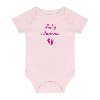 A light pink short-sleeve baby bodysuit with 'Baby Andrews' and baby footprints embroidered in pink on the chest, displayed on a solid white background.