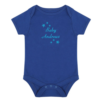 A royal blue short-sleeve baby bodysuit with 'Baby Andrews' embroidered in light blue script across the chest, surrounded by small light blue stars, shown on a plain white background.
