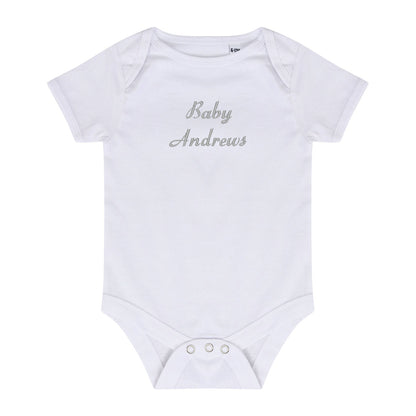A white short-sleeve baby bodysuit with 'Baby Andrews' embroidered in a silver cursive font on the chest, displayed flat against a white background.