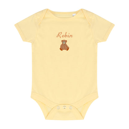 A pale yellow short-sleeve baby bodysuit with 'Robin' and a small brown teddy bear graphic embroidered on the chest, displayed flat against a white background.