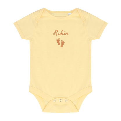 A pale yellow short-sleeve baby bodysuit with 'Robin' and baby footprints embroidered in brown on the chest, displayed flat against a white background.